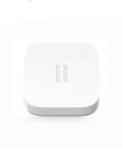 Smart Vibration Sensor Alarm placed on an opened book, showcasing its compact and sleek design.