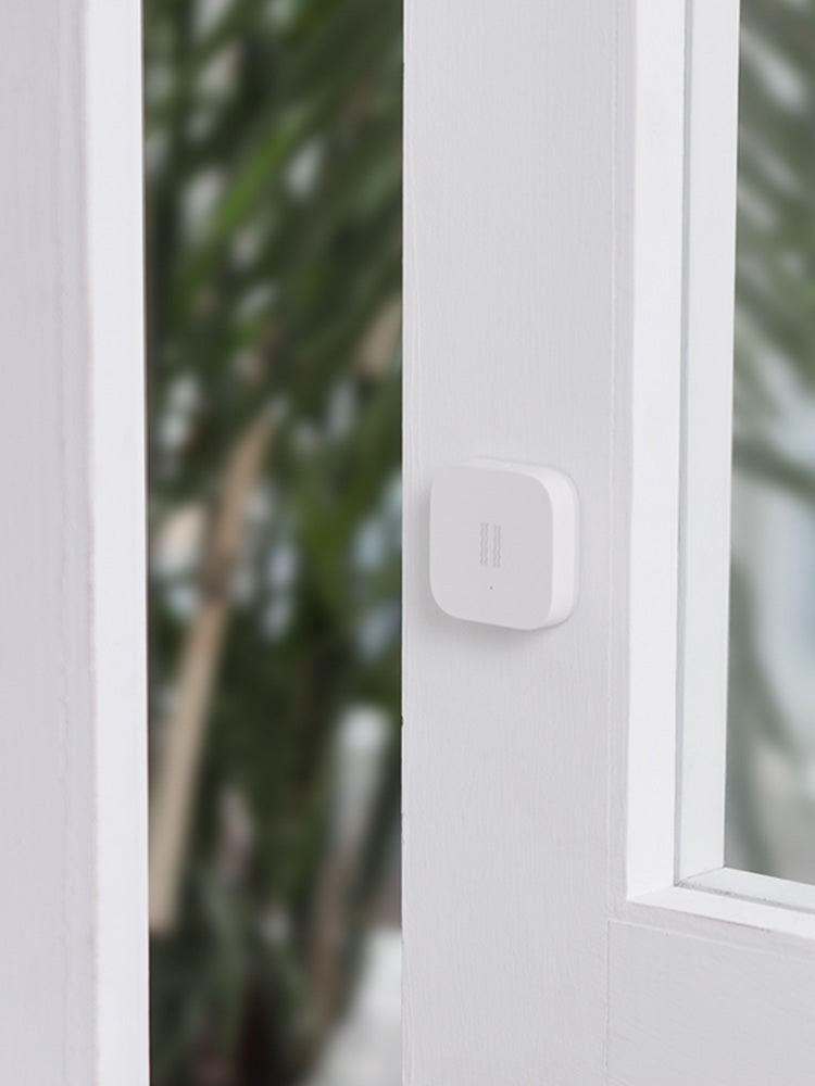Smart Vibration Sensor Alarm placed on an opened book, showcasing its compact and sleek design.