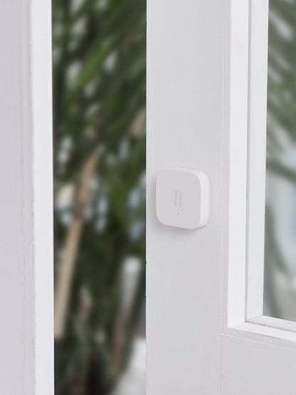 Smart Vibration Sensor Alarm placed on an opened book, showcasing its compact and sleek design.