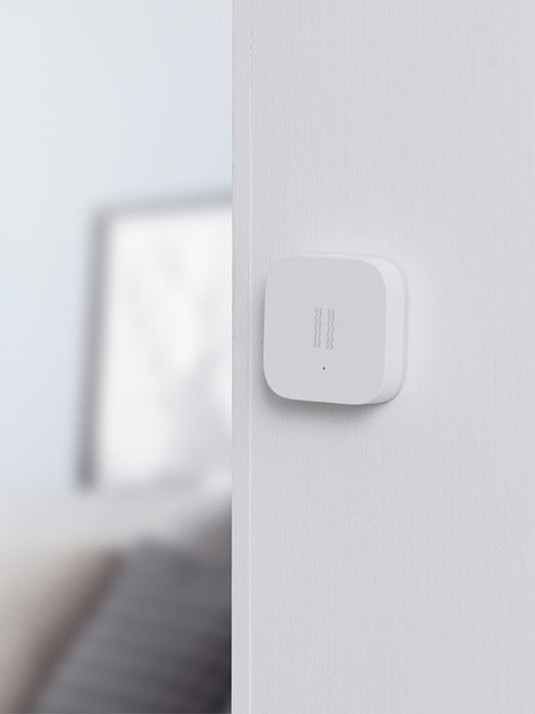 Smart Vibration Sensor Alarm placed on an opened book, showcasing its compact and sleek design.