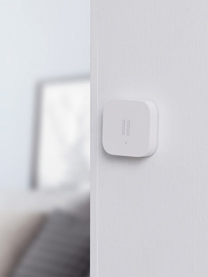 Smart Vibration Sensor Alarm placed on an opened book, showcasing its compact and sleek design.
